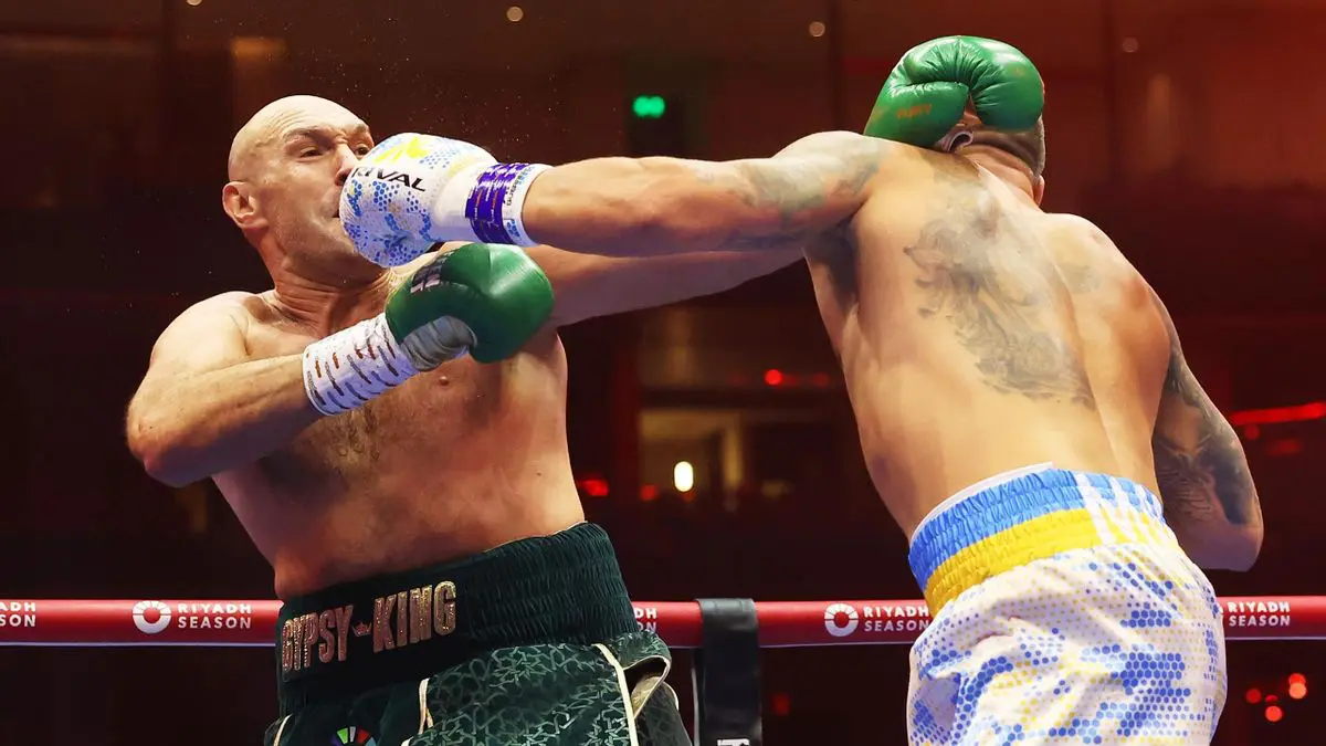 Usyk in tears for late father after historic heavyweight win